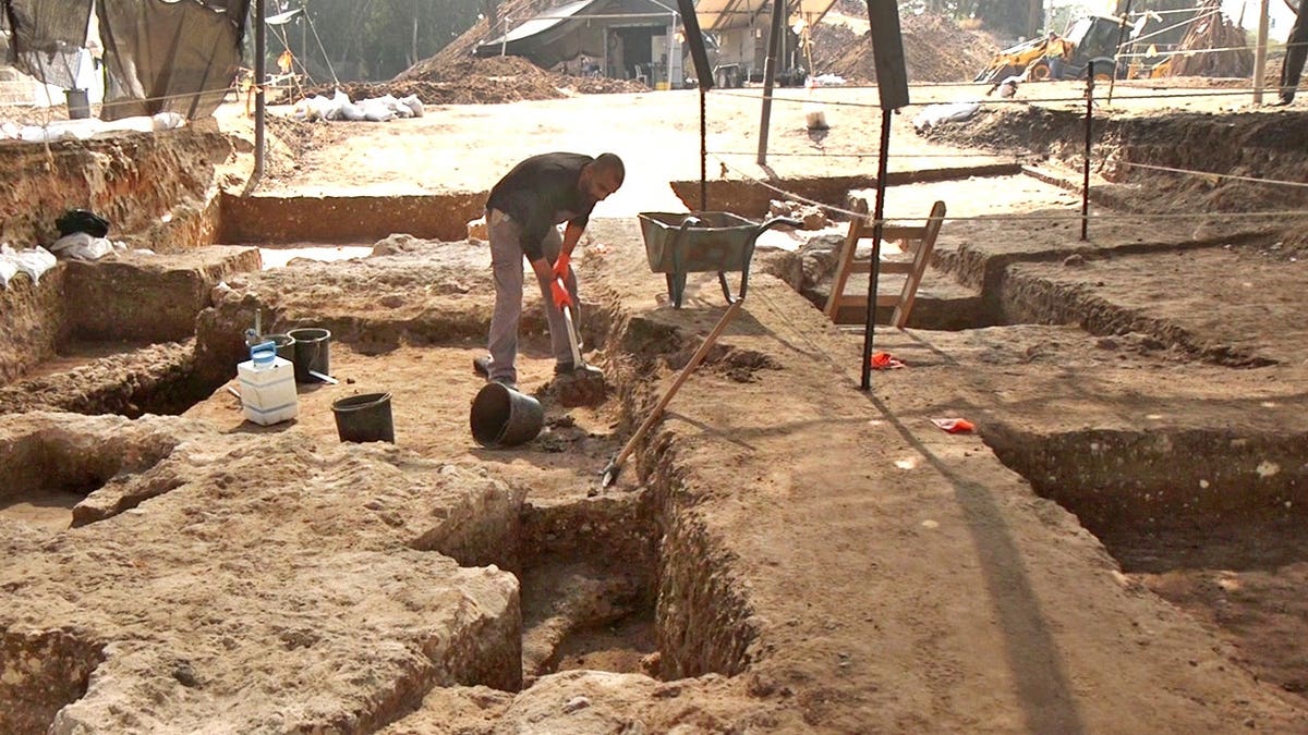 Archaeologist digging at excavation site