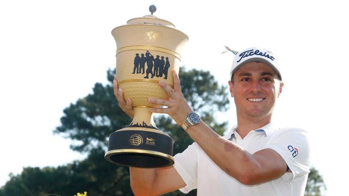 Justin Thomas holds up the Gary Player Cup after winning the 2020 WGC FedEx St. Jude Invitational at TPC Southwind in Memphis, Tennessee.