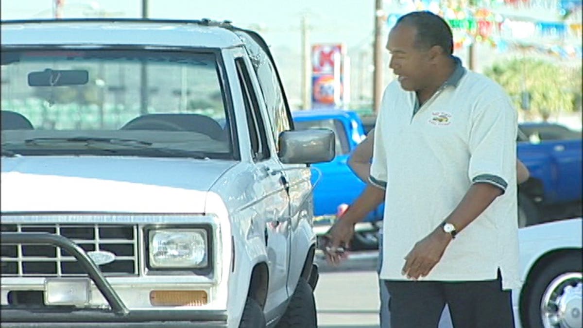 O.J. Simpson walking next to a white Bronco.