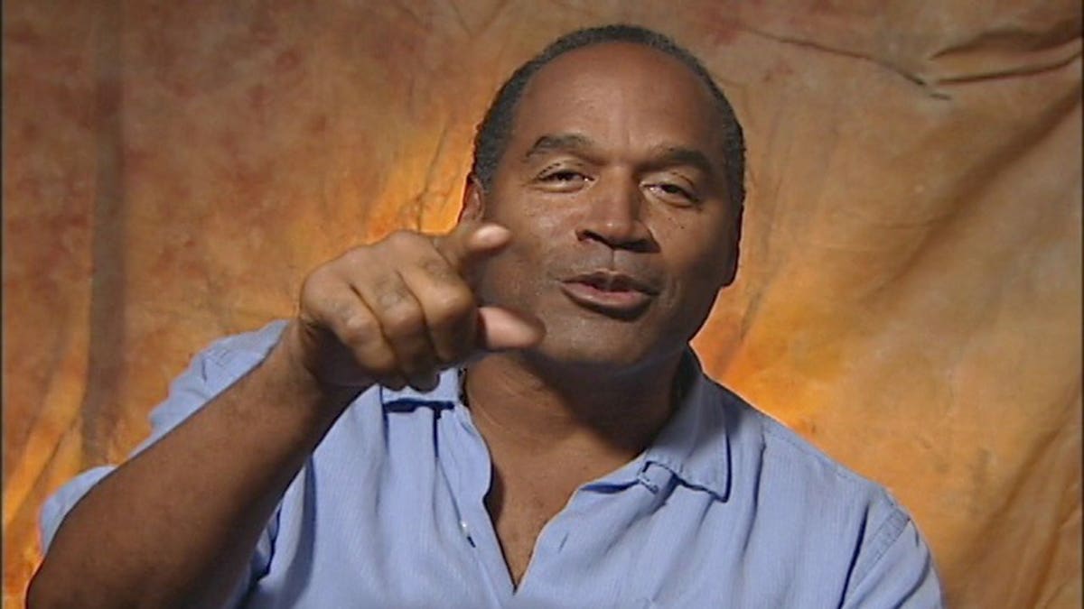 O.J. Simpson mid-sentence in a blue shirt.
