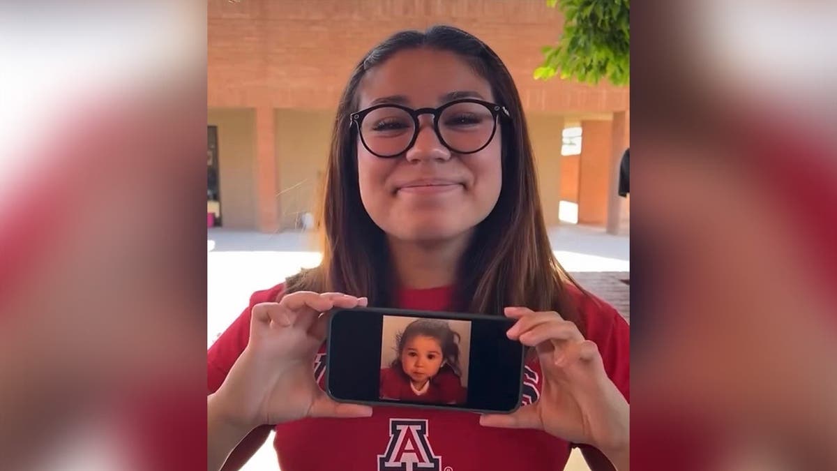 image shows Julie holding a phone