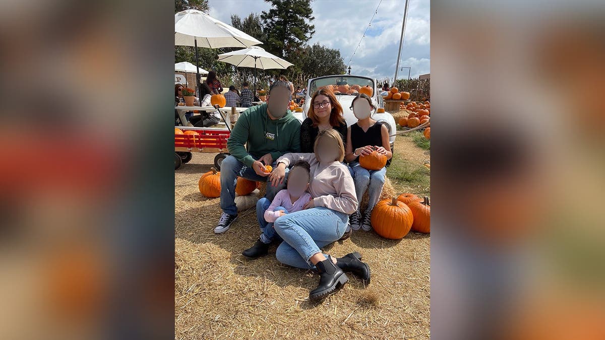 image shows Julie and her family at a pumpkin patch
