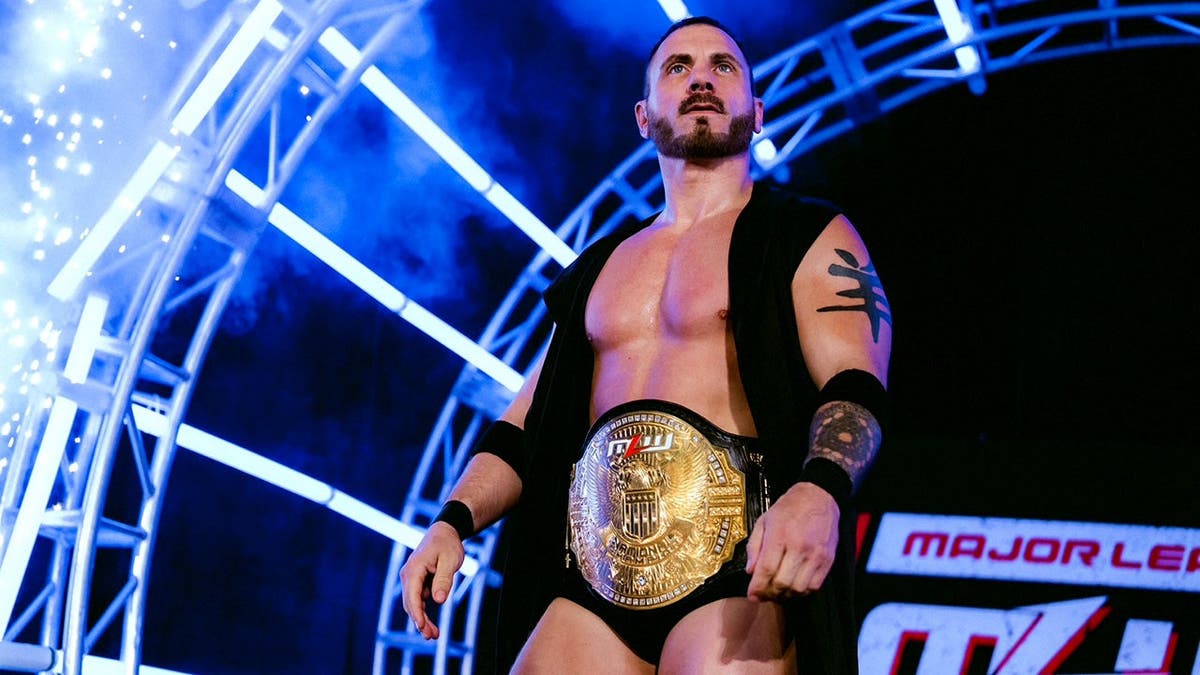 Austin Aries with his title around his waist