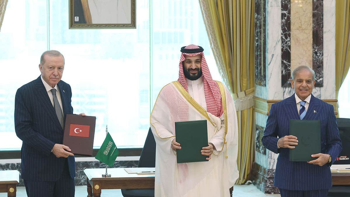 Turkish President Recep Tayyip Erdogan (L), Saudi Crown Prince Mohammed bin Salman (C) and Pakistani Prime Minister Shehbaz Sharif (R) sign a trilateral joint defense agreement in Mecca