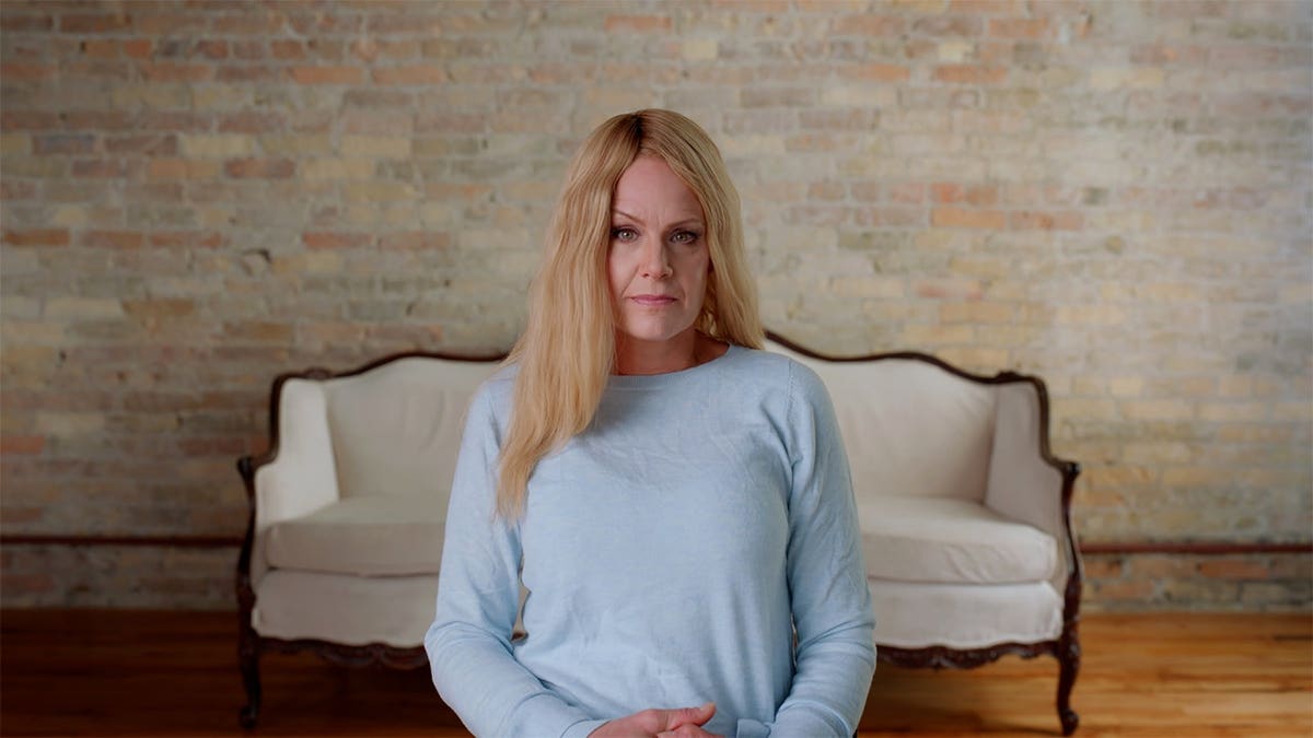 Christie Prody wearing a light blue shirt looking serious.