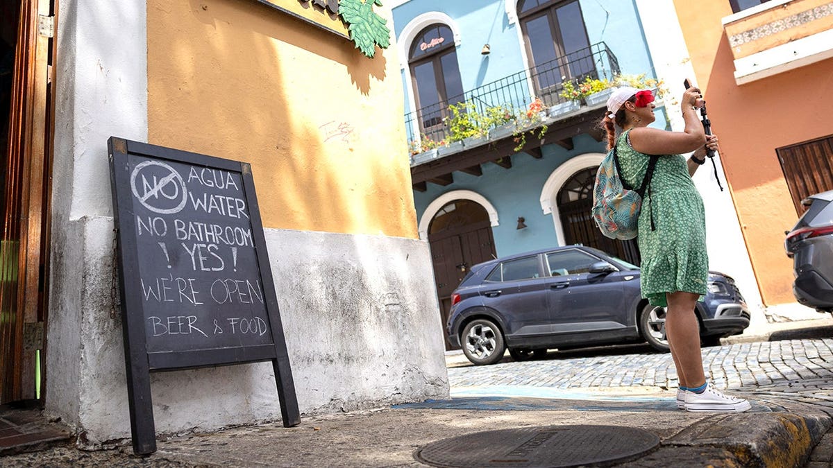 Tourist taking picture next to no water sign in PR