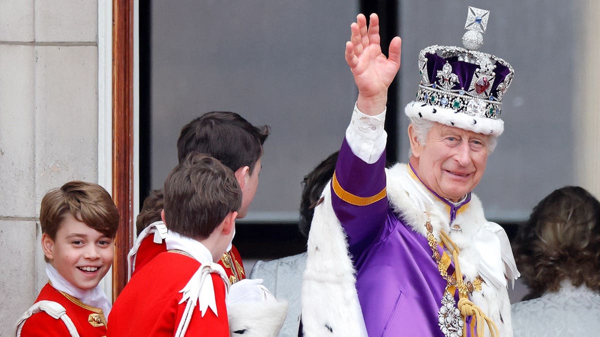 Prince George and King Charles III watch an RAF flypast from the Buckingham Palace balcony.