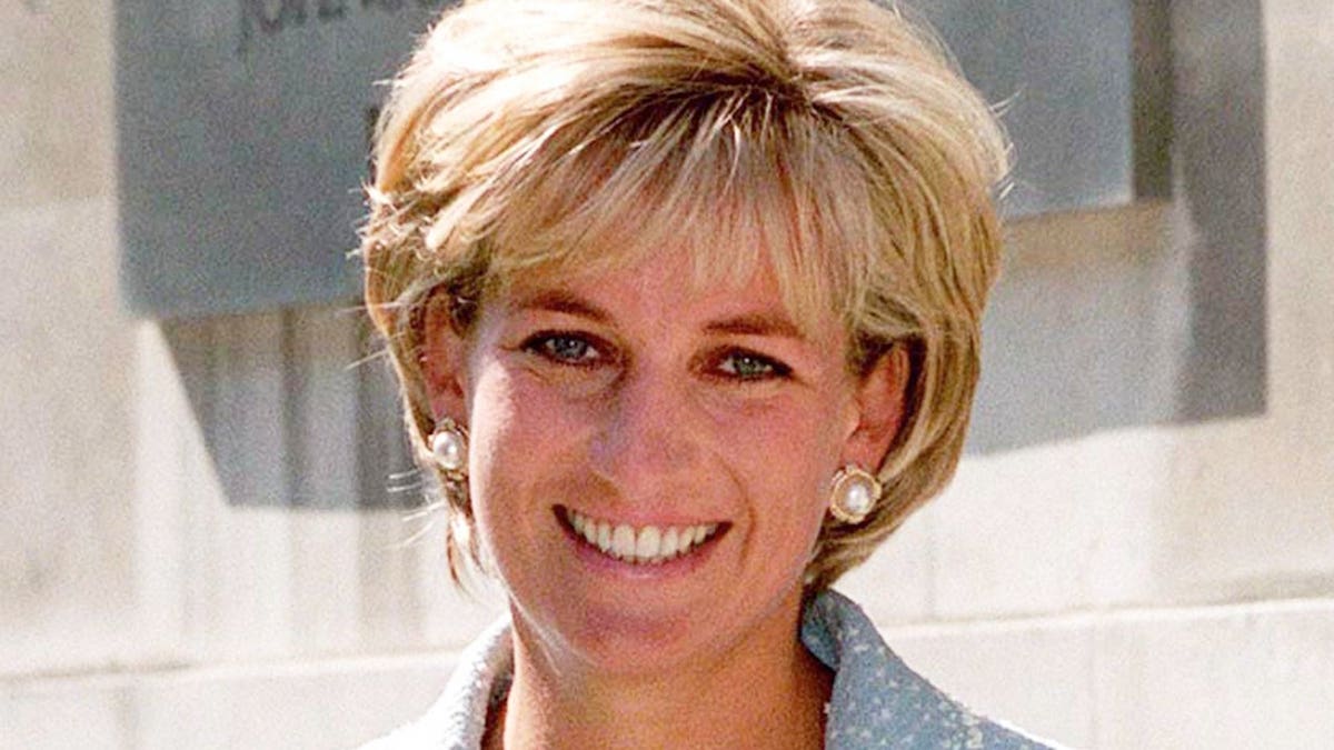 Diana, Princess of Wales, holds a bouquet while leaving a building in London.