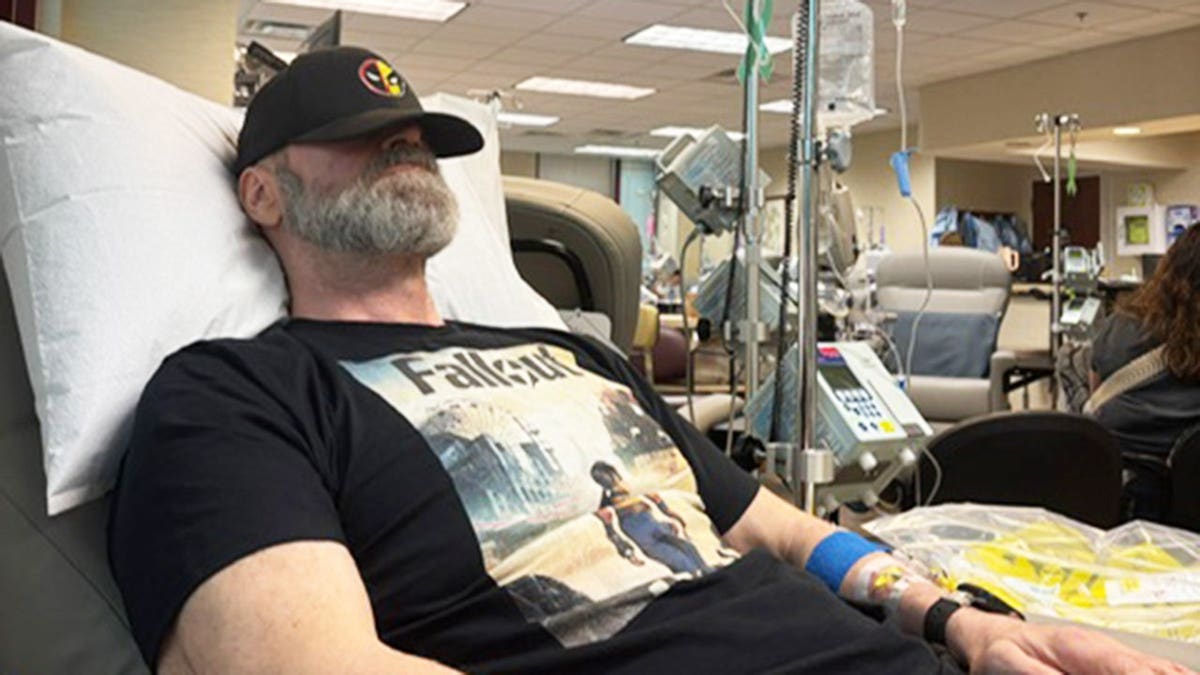 Tyler Mane with his black hat covering his face as he gets treatment at a hospital for breast cancer.