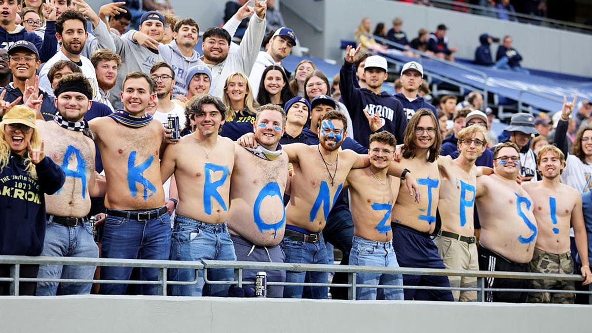 Akron Zips fans sit in the stands during a college football game.