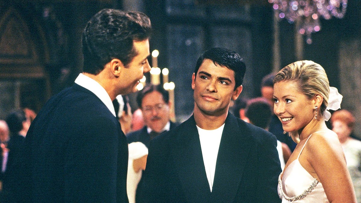 Kelly Ripa, Mark Consuelos and Matt Borlenghi stand together at a wedding scene on the set of All My Children.