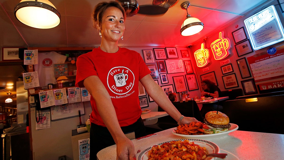 Amanda Wihby holds two plates of food from The Red Arrow Diner in New Hampshire in 2014.
