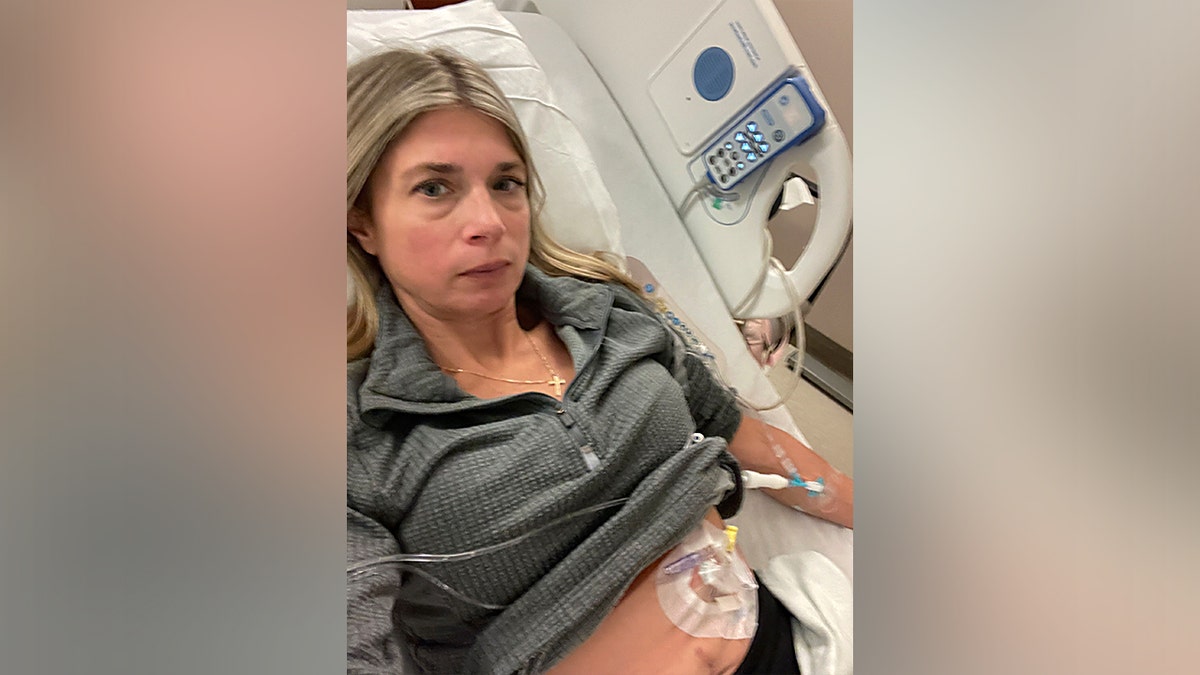 Ashley Papa laying in a medical bed with an IV attached.