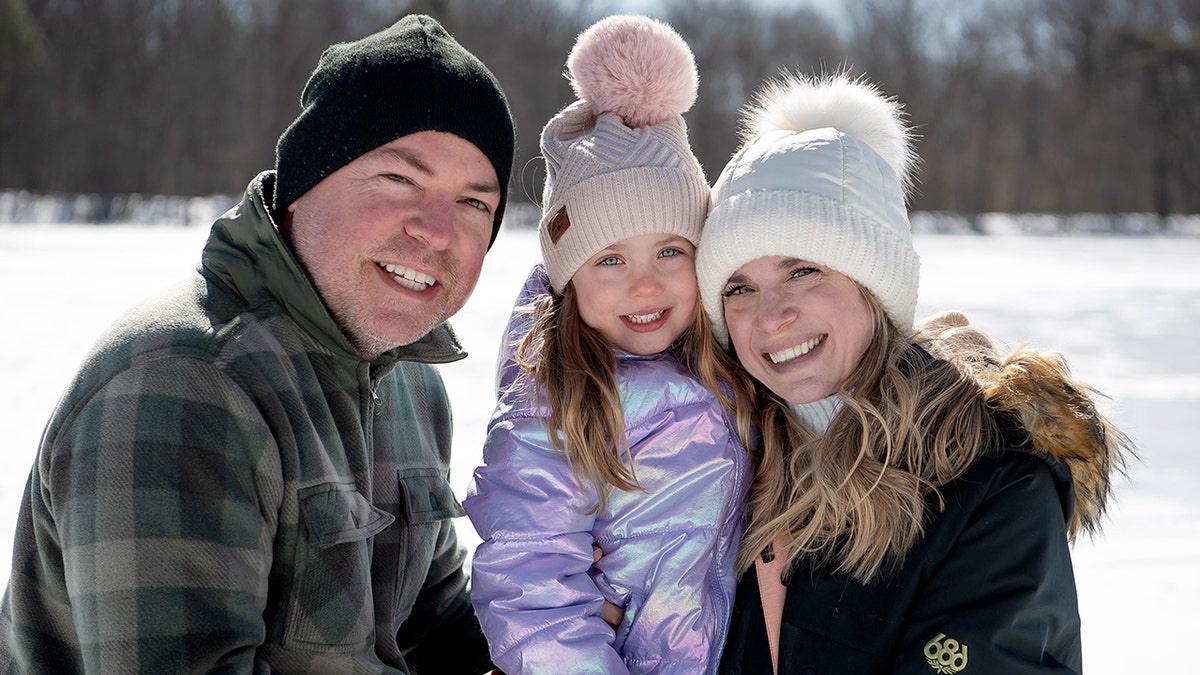 Ashley Papa poses with her daughter and husband.
