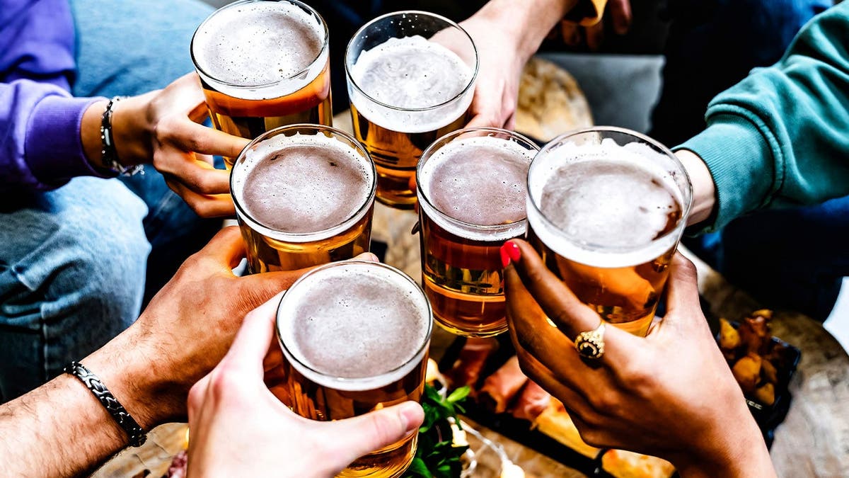 People cheers with mugs of beer.