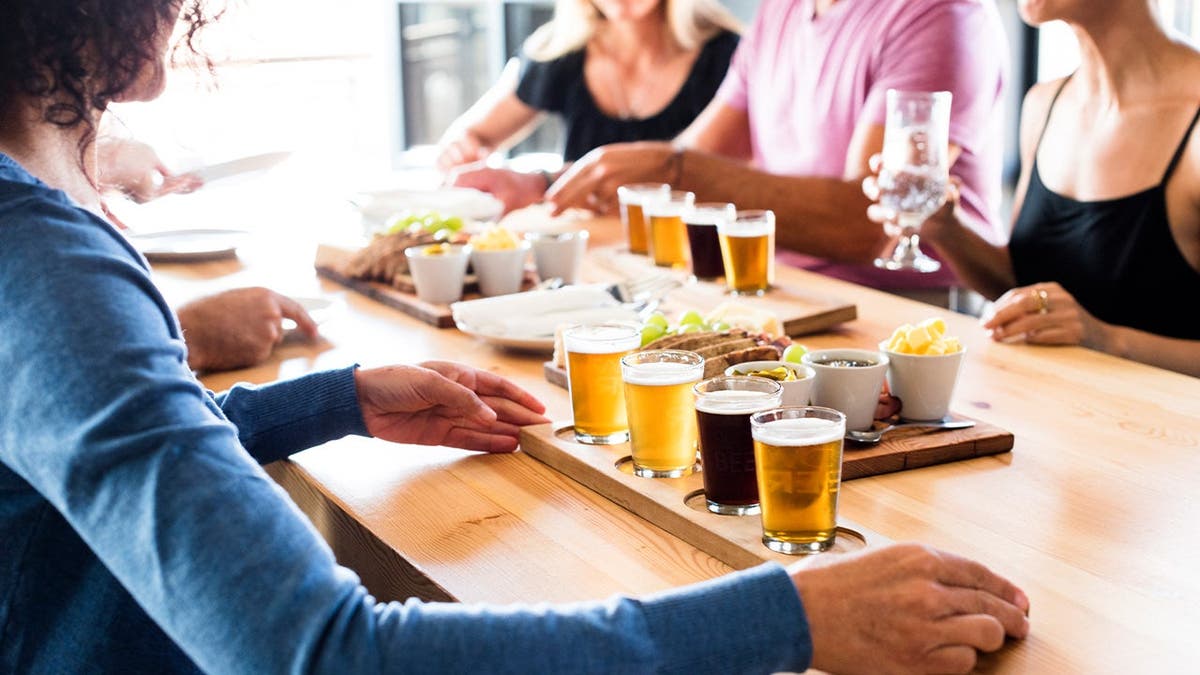 A server presents a flight of beer.