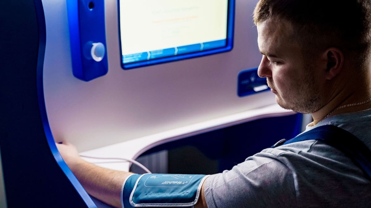 A person using a blood pressure cuff
