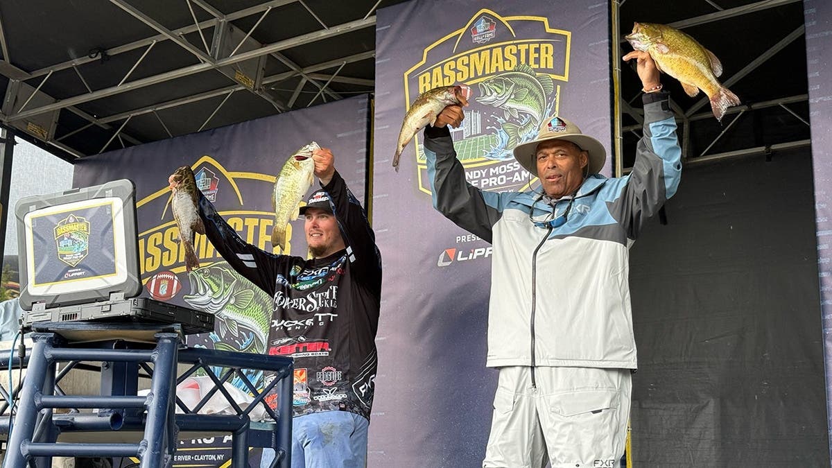 Robert Brazile and Tyler Williams hold up their fish on stage