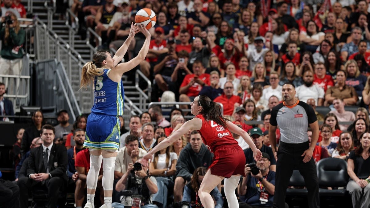 Dallas Wings All-Star Paige Bueckers shoots a 3-pointer over Indiana Fever All-Star Caitlin Clark at Gainbridge Fieldhouse.