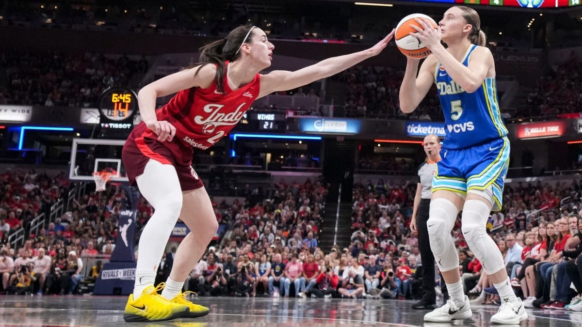 Dallas Wings guard Paige Bueckers gathers to shoot over Indiana Fever guard Caitlin Clark at Gainbridge Fieldhouse.