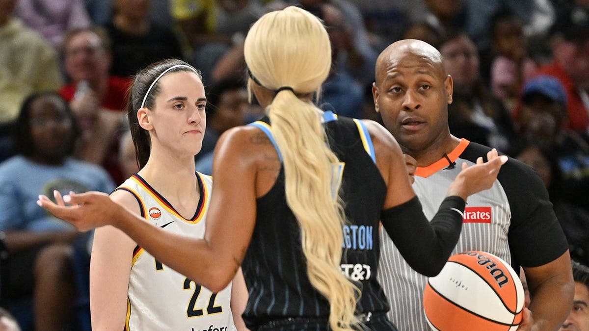 Caitlin Clark looks to pass the ball in bounds against DiJonai Carrington during a WNBA game.