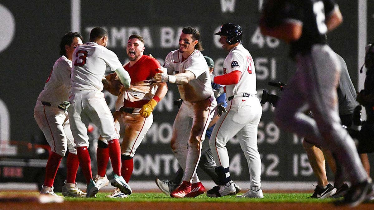 Caleb Durbin celebrates with Jarren Duran and Ceddanne Rafaela after hitting a walk-off single at Fenway Park.