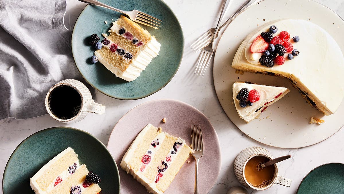 A selection of Whole Foods' Berry Chantilly Cake sits on a table.
