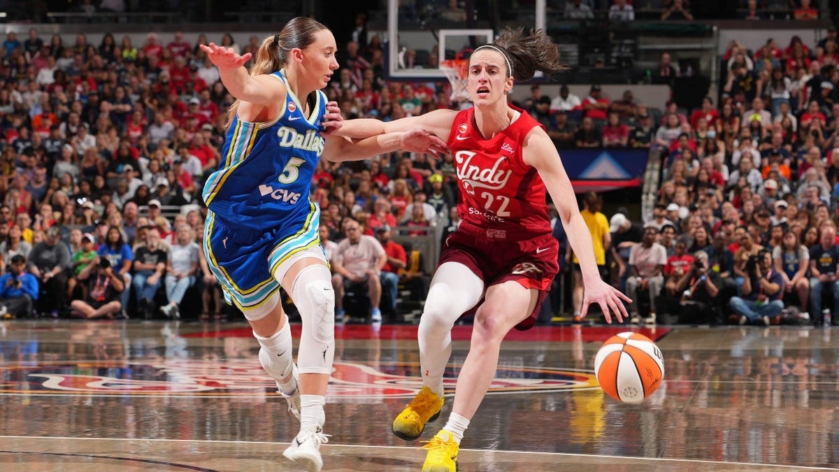 Indiana Fever guard Caitlin Clark handles the ball vs. Dallas Wings guard Paige Bueckers at Gainbridge Fieldhouse.