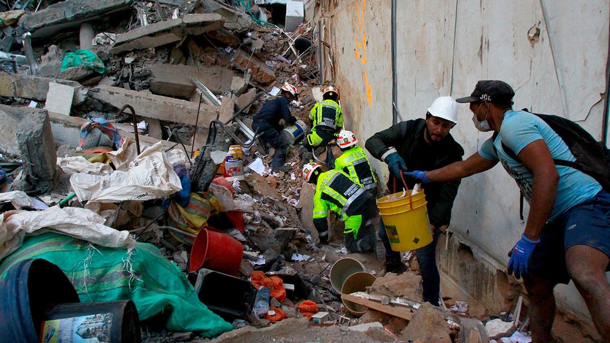 Rescue workers and volunteers clear debris in Pereira, Colombia.