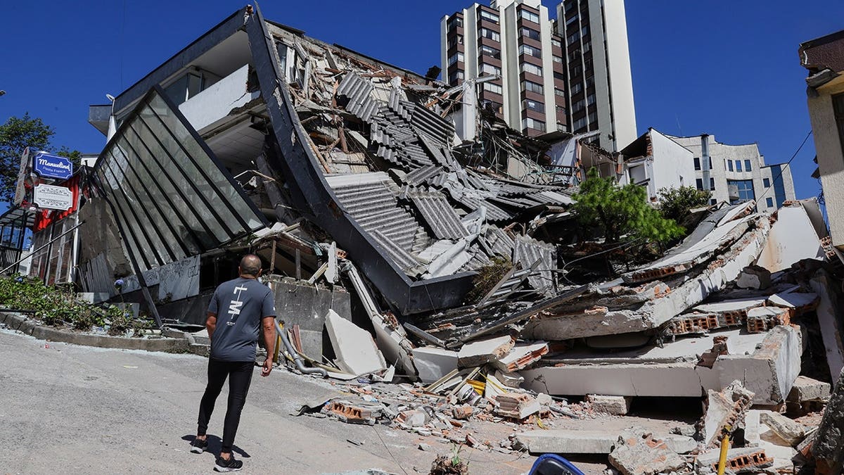 A man looks at a collapsed building in Manizales, Colombia.