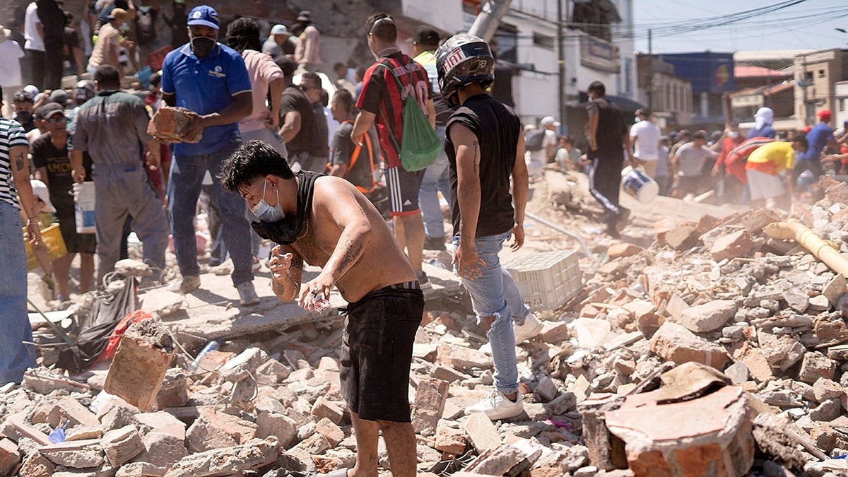 Residents dig through debris of a collapsed building in Cali, Colombia.
