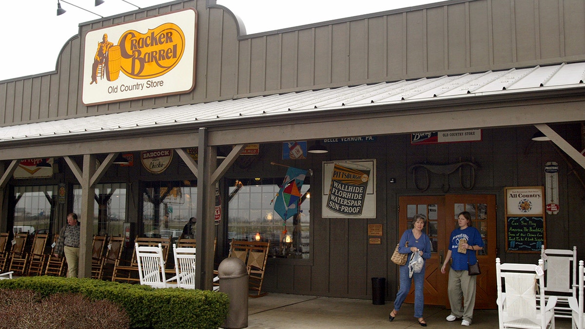 Two women leave a Cracker Barrel Old Country Store carrying items.