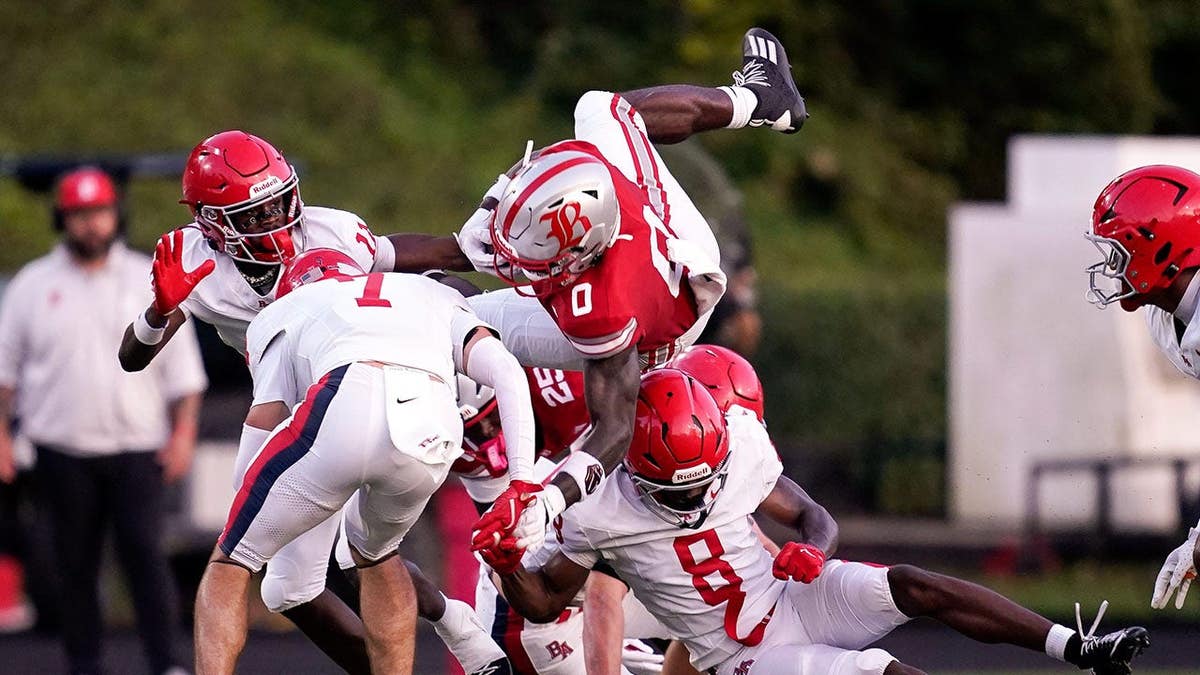 David Gabriel Georges is tripped by Hill Strong and Braylen Bedford during a football game.