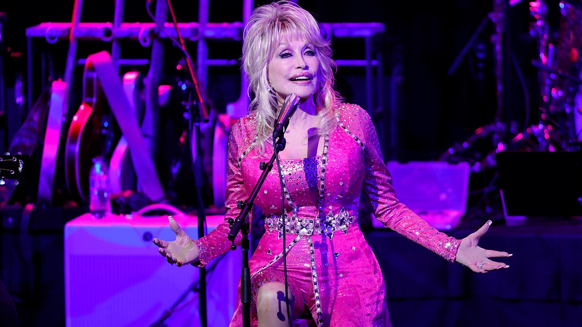 Dolly Parton on stage in pink.