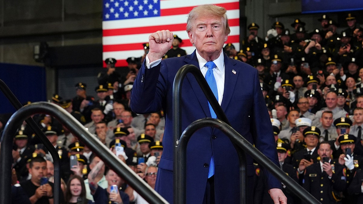President Donald Trump raises fist after speech in New York