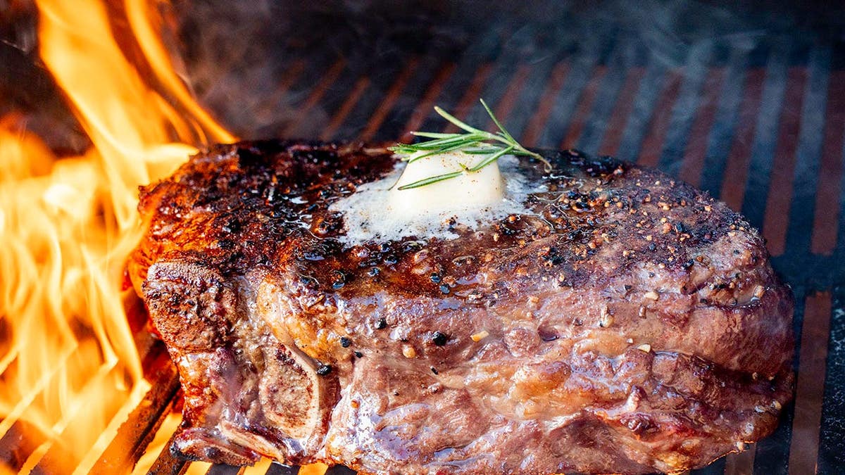 Seared Tomahawk Steak with Rosemary and Butter on Open Flame Grill