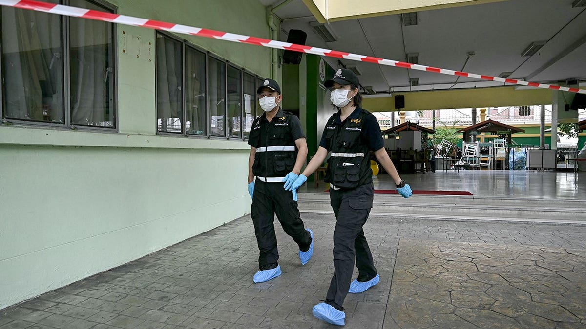 Forensic police walk at the scene of the school shooting in Thailand.