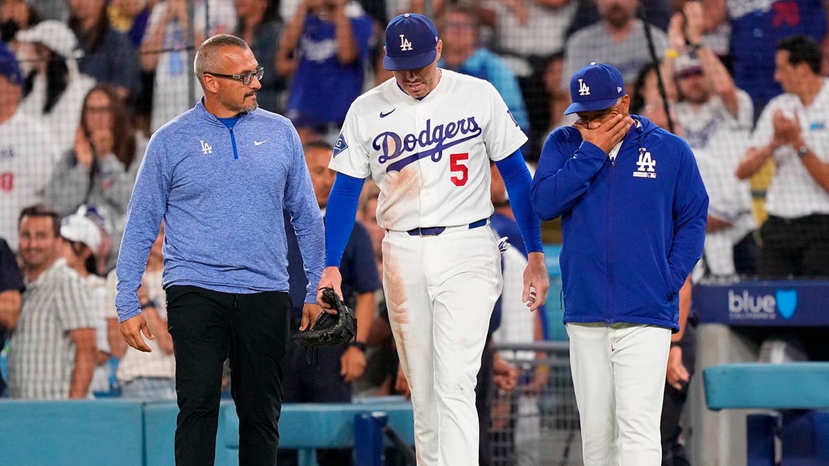 Freddie Freeman vuelve al campo acompañado por el entrenador Dave Roberts y el preparador físico Greg Barajas.