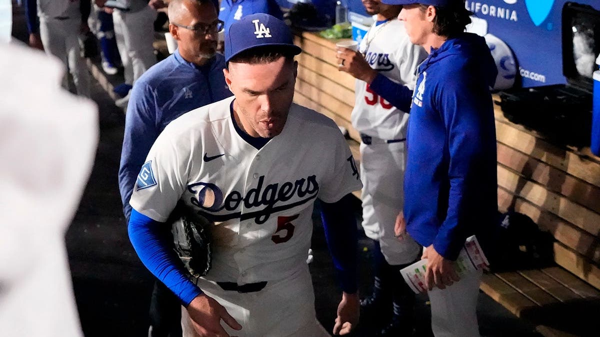 Freddie Freeman sale del campo tras caer en el banquillo de los visitantes mientras intentaba atrapar una bola fuera de juego.