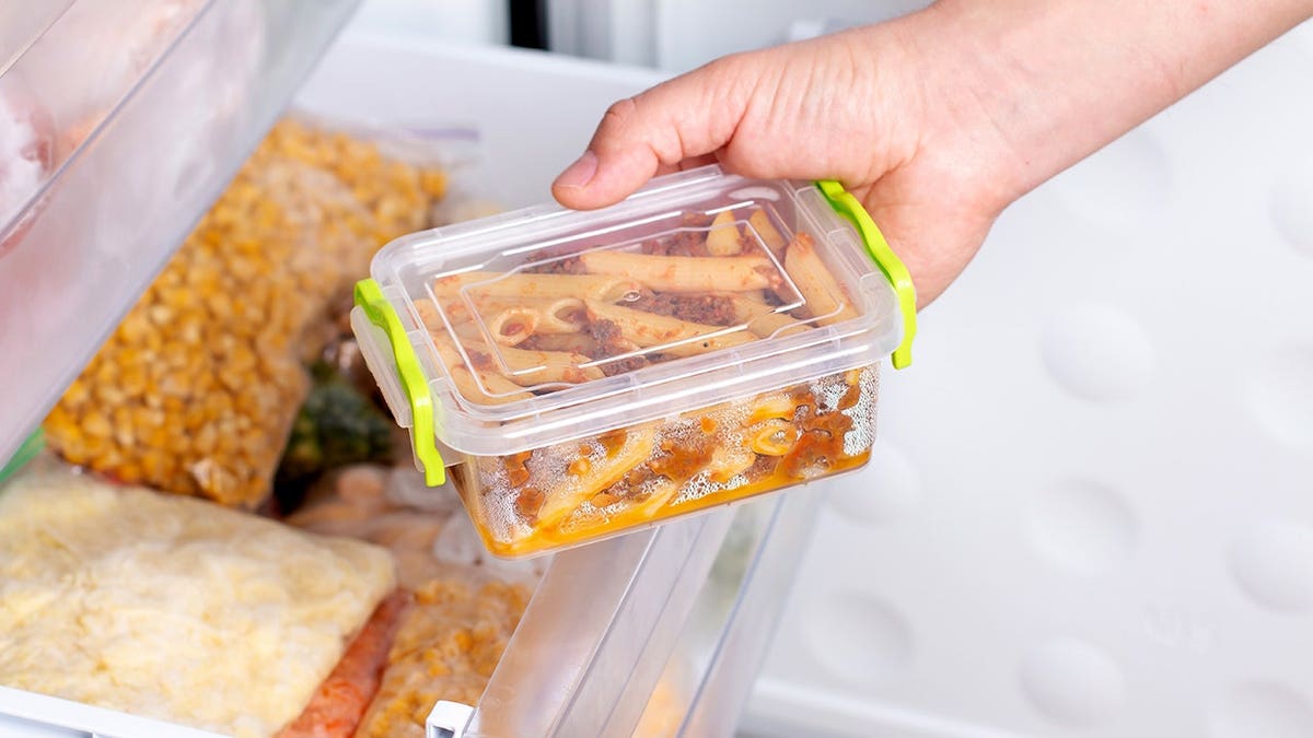 Frozen pasta with minced meat sits in a freezer compartment.