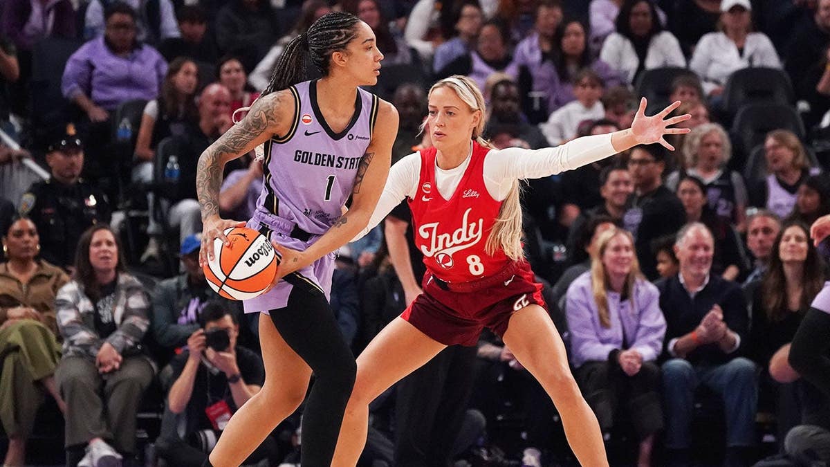 Gabby Williams of the Golden State Valkyries is defended by Sophie Cunningham of the Indiana Fever.