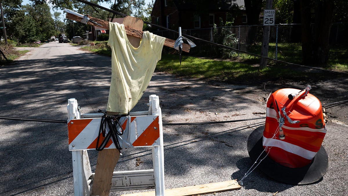 A makeshift road block prevents drivers from driving through downed utility lines stretching across a street on August 20, 2026 in Gary, Indiana. The lines were brought down during a derecho storm that left many residents of Gary without power for more than nine days.