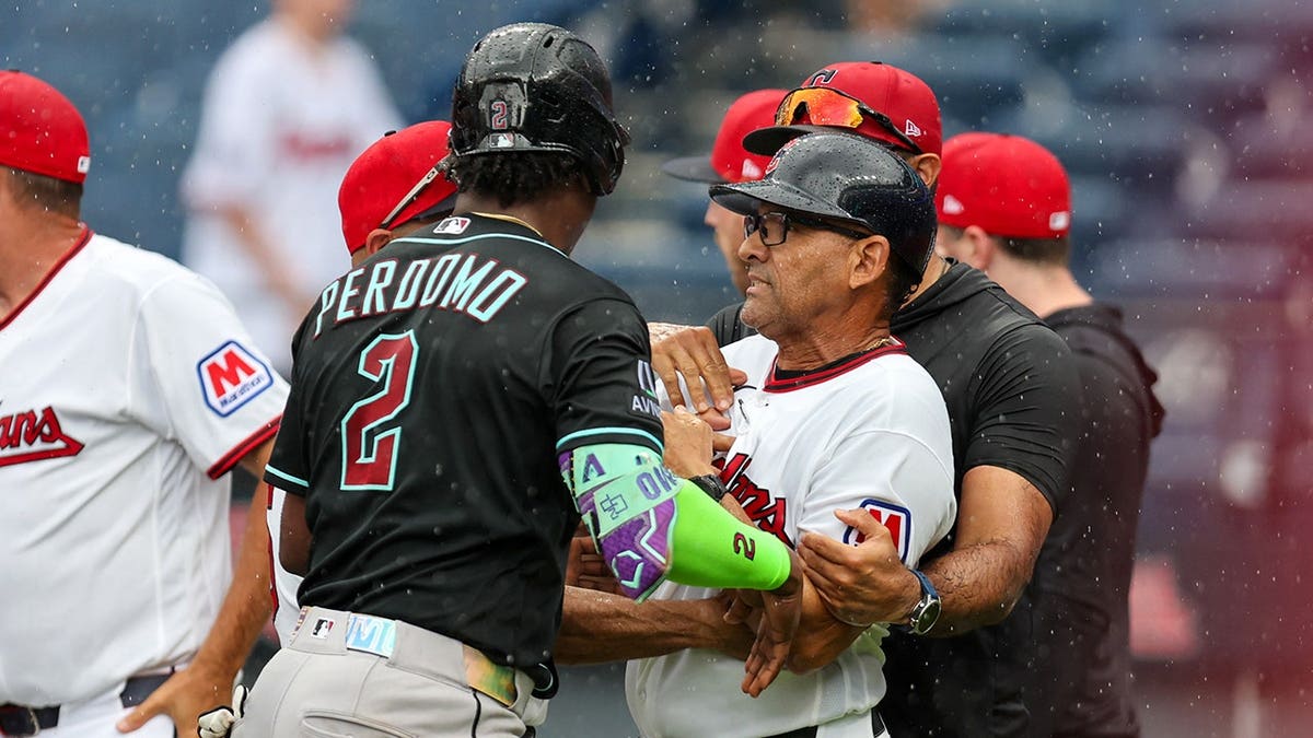 Geraldo Perdomo separates Rouglas Odor during a bench-clearing scene at Progressive Field.