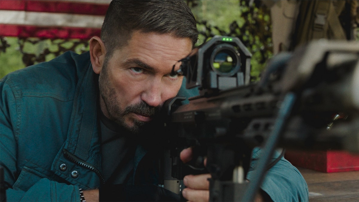Jim Caviezel holding a gun