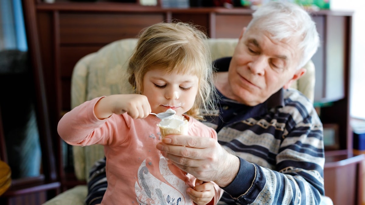 Grandpa giving toddler ice cream