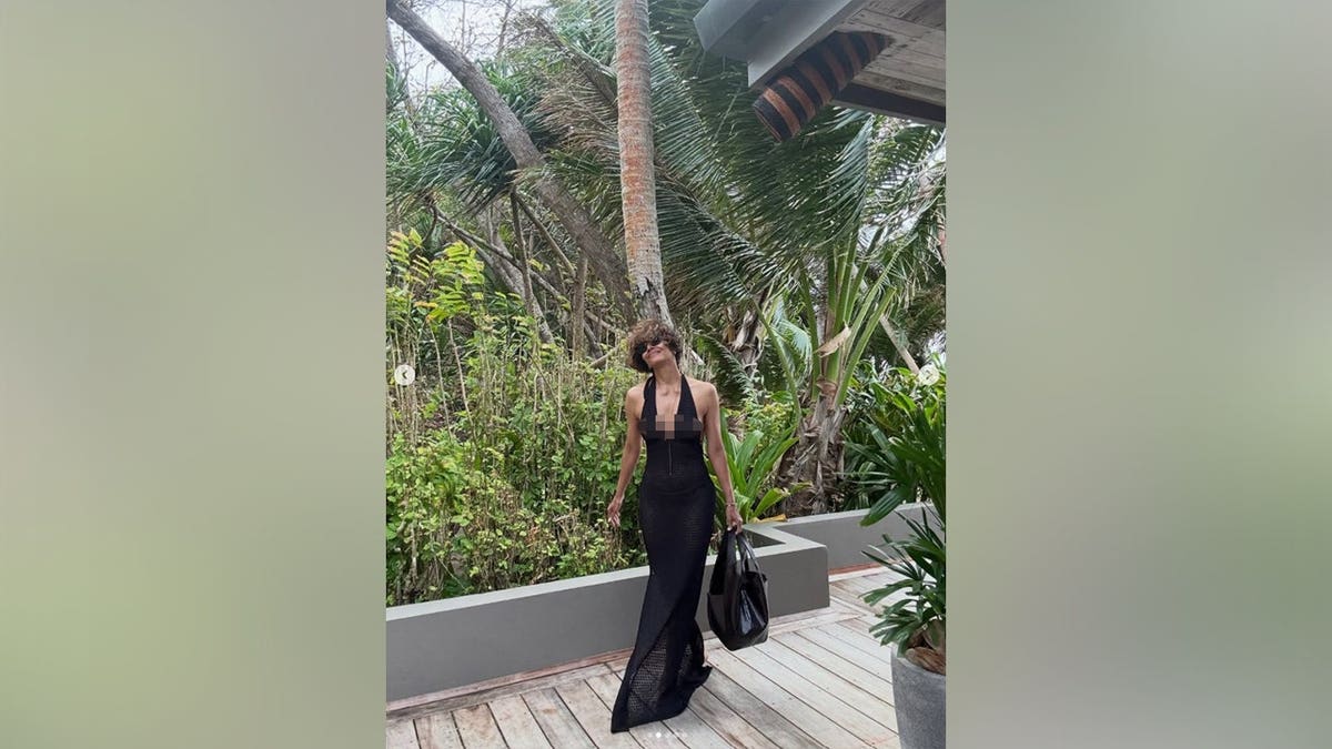 Halle Berry in a black floor-length dress with a plunging halter neckline.