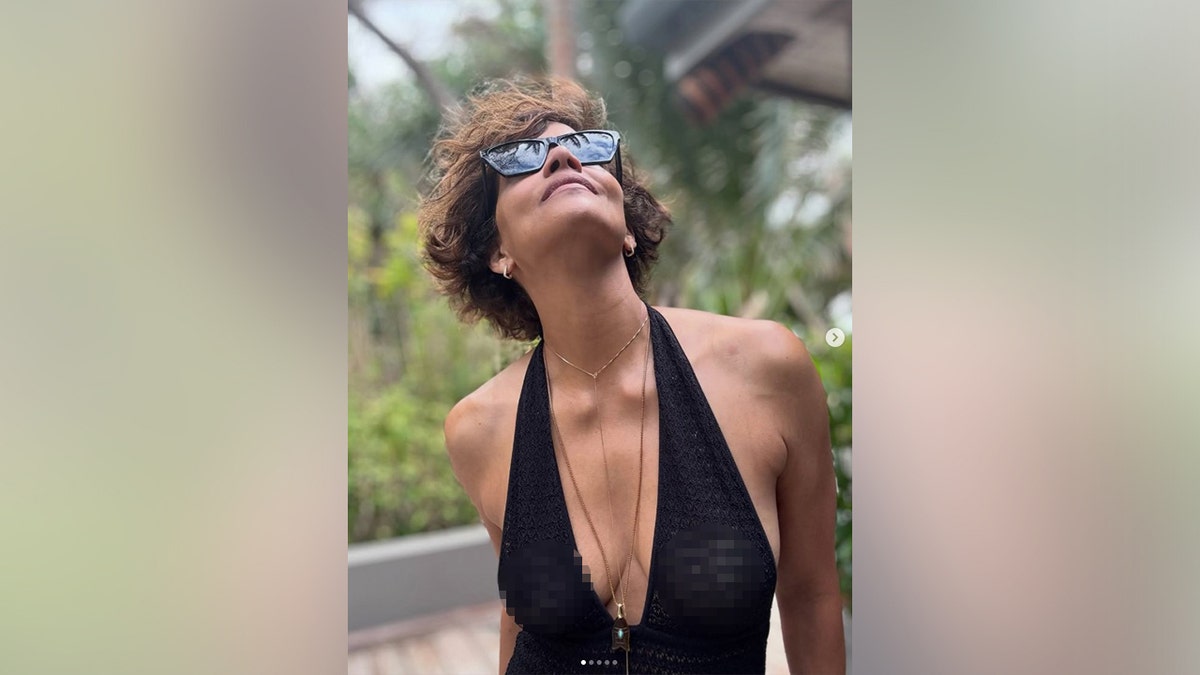 Halle Berry in a black knit dress with a plunging neckline.