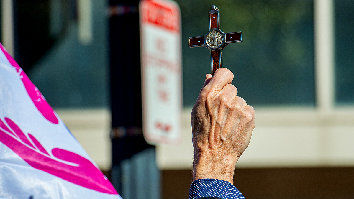 Man holding up a cross