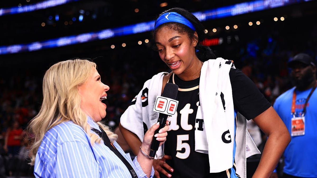 Reporter Holly Rowe speaks with Angel Reese #5 of the Atlanta Dream during a game.