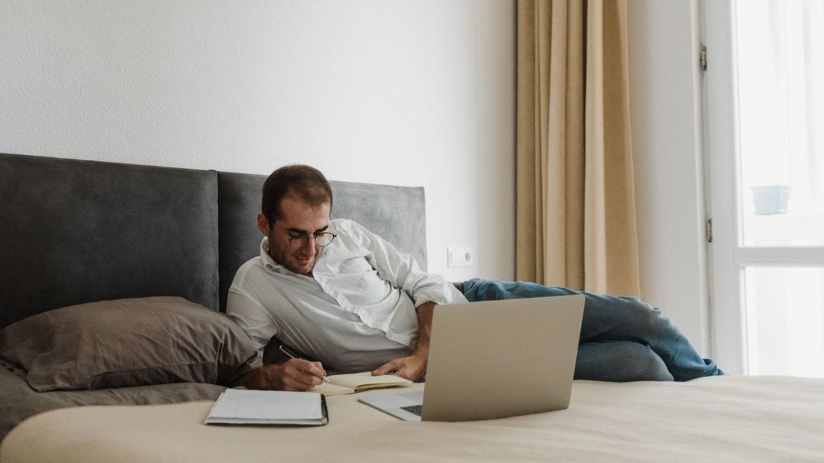 A man on a computer in a hotel room
